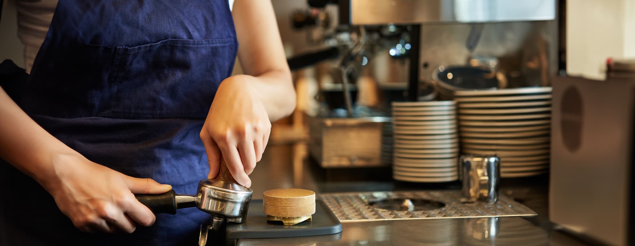 close-up-barista-female-hands-pressing-coffee-into-tamper-prepares-order-cafe-counter.jpg